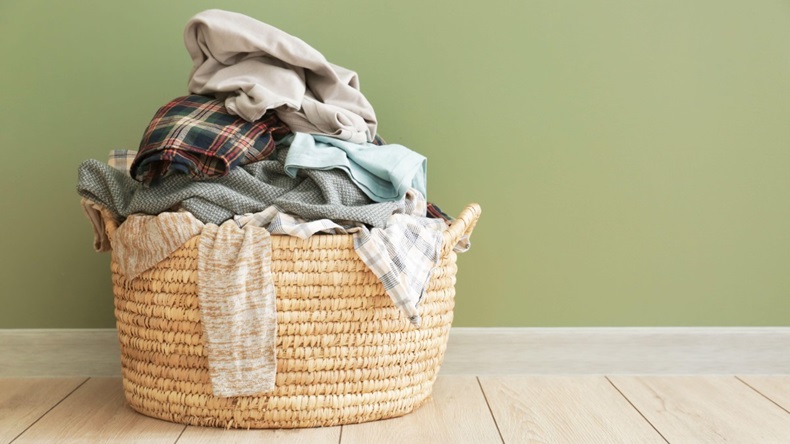 Basket with dirty laundry on floor