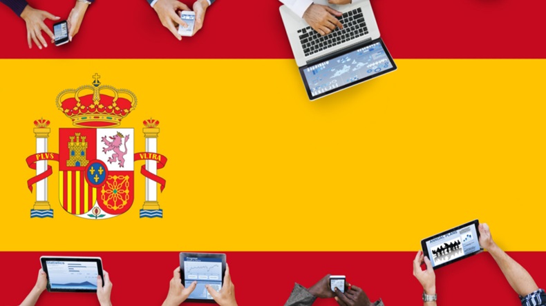 Spanish flag adorned with arms of people in business meeting