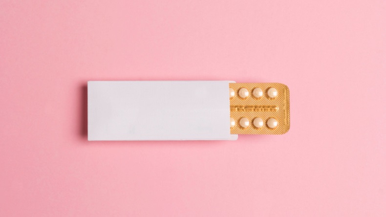 Pack of contraceptive pills against pink background