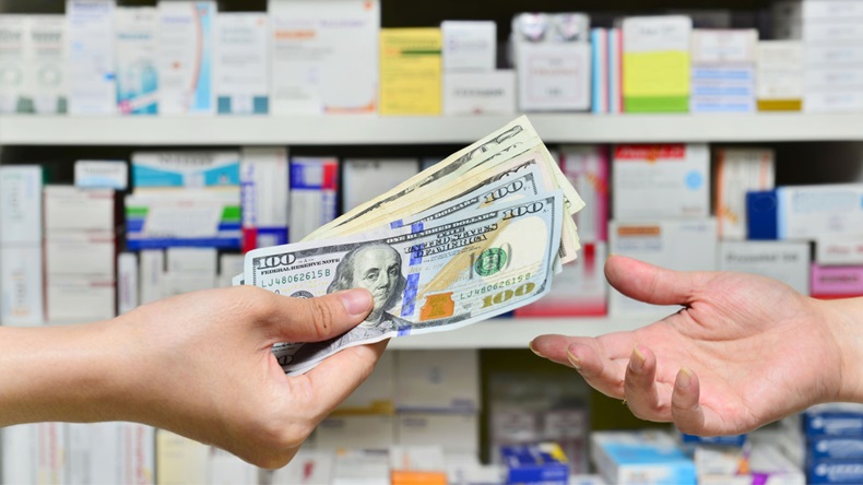 Buyer passing cash to pharmacist in US drugstore
