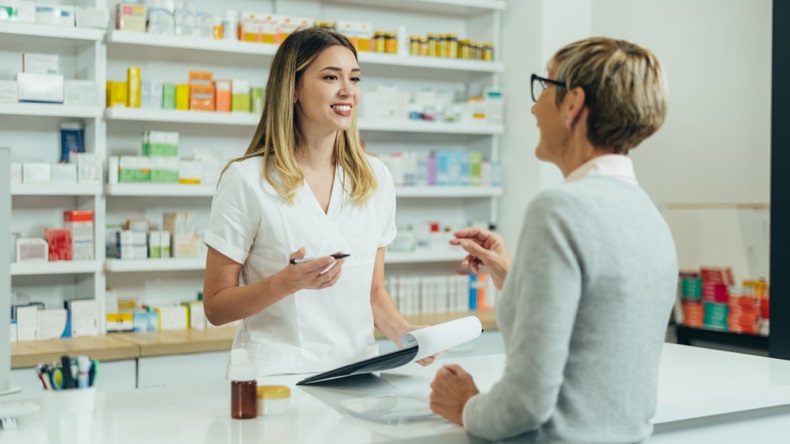Pharmacist speaking to patient at counter