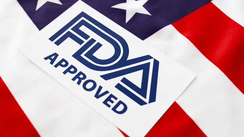 Label that reads "FDA APPROVED" on top a portion of the American Flag