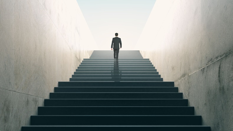 Ambition concept with businessman climbing stairs