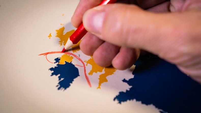 Hand drawing a red line between the UK and Northern Ireland