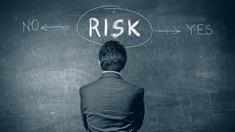 Businessman at chalkboard considers risk - yes or no?