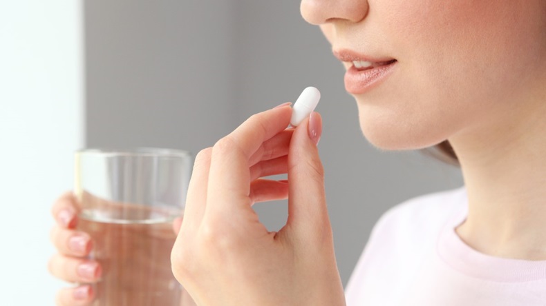 Woman Taking Pill With Glass Of Water