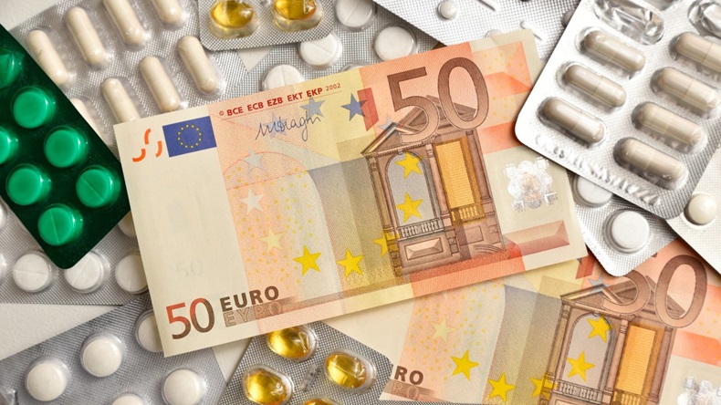 Euro banknote and pills on white background. Symbolizing health care costs in European Union.
