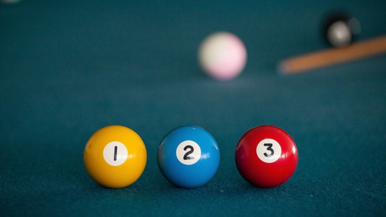 Three Numbered Pool Balls With Cue And White Ball