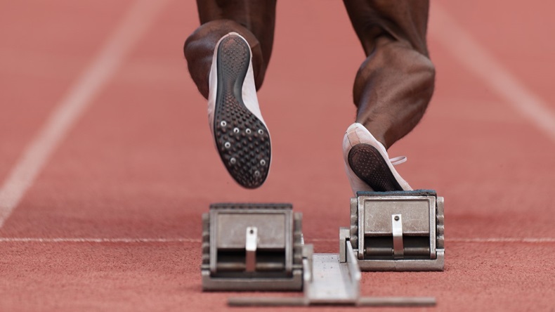 Sprinter coming out of blocks on racetrack