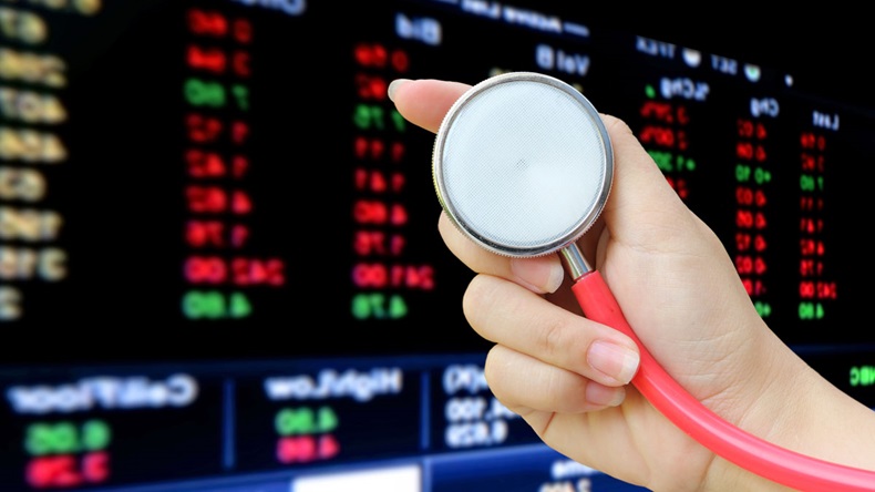 hand holding stethoscope with blur perspective stock market number background