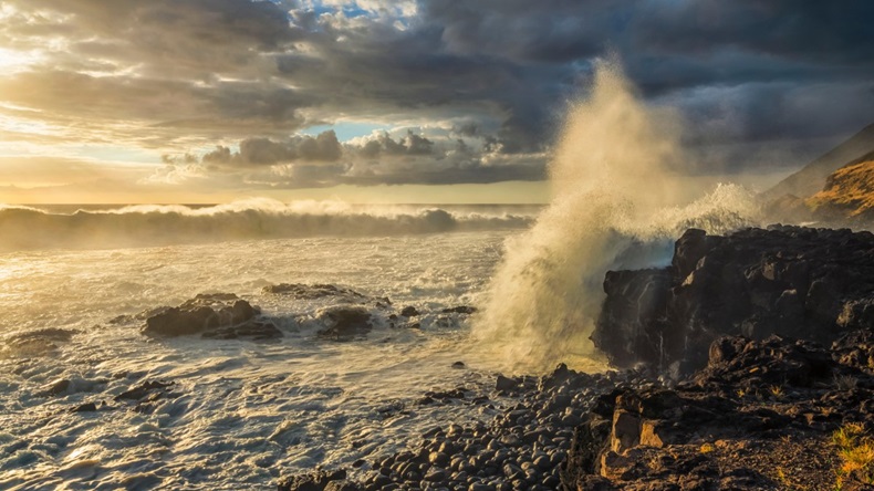 Waves crashing against the shoreline at sunset along the Western coast of Oahu