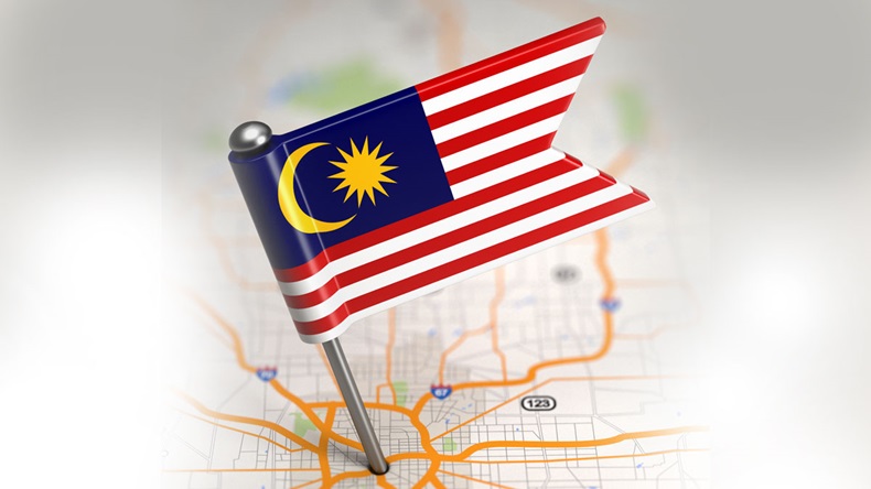 Small Flag of Malaysia Sticked in the Map Background with Selective Focus.